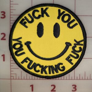 Yellow smiley face patch with explicit black text.