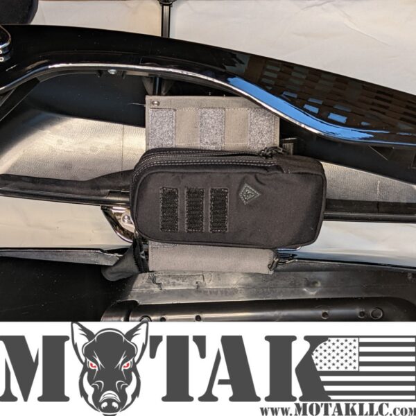 Black tactical pouch attached to a grey organizer panel inside a motorcycle saddlebag, with a black Motak logo visible.