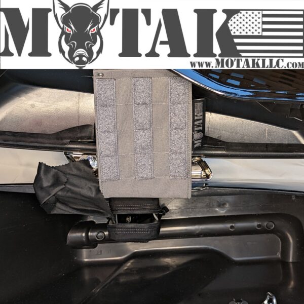 Grey saddlebag organizer panel with a black pouch securely attached inside a motorcycle saddlebag. The Motak logo and website URL are displayed at the top.