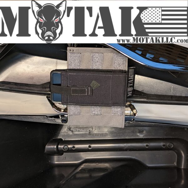 Grey saddlebag organizer panel with a black pouch and phone holder, securely attached inside a motorcycle saddlebag. The Motak logo and website URL are displayed at the top.