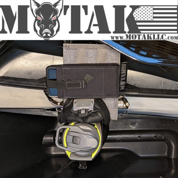 Grey saddlebag organizer panel with a black pouch, phone holder, and water bottle securely attached inside a motorcycle saddlebag. The Motak logo and website URL are displayed at the top.