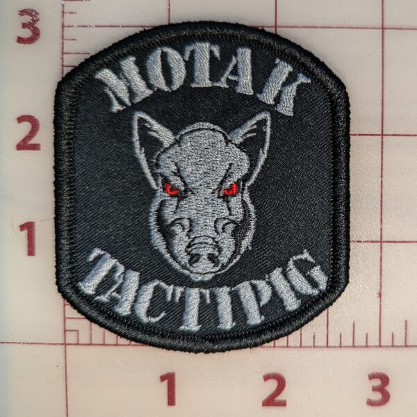 MOTAK Tactipig patch with a fierce boar's head logo and red eyes on a black background.